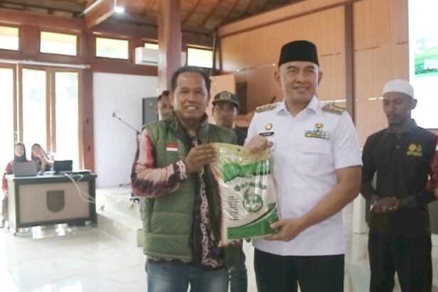 Bupati Rahmat menerima beras kemasan diserahkan simbolis oleh Budi Ansyari selaku Bridge Pangan wilayah Asam-asam. Foto: Asep/siberdbn.com